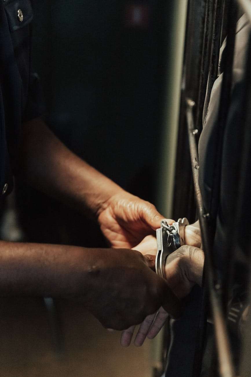 handcuffs on hands of prisoner in jail